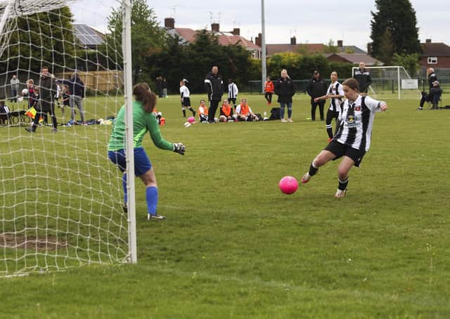 Libby Willis (stripes) scores for Peterborough Northern Star Under 16s against Saffron Walden. Photo: Tim Symonds.
