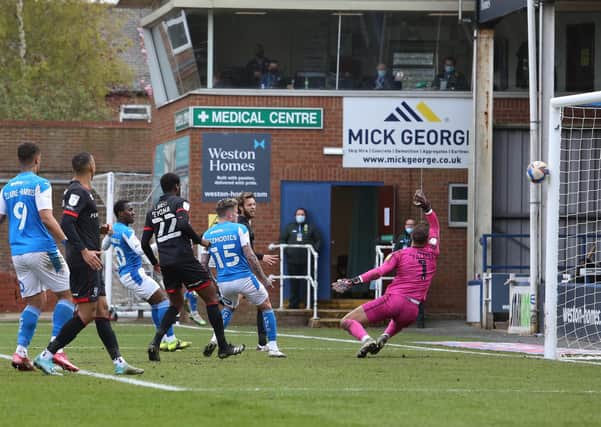Siriki Dembele (blue, centre) scores for Posh against Lincoln.