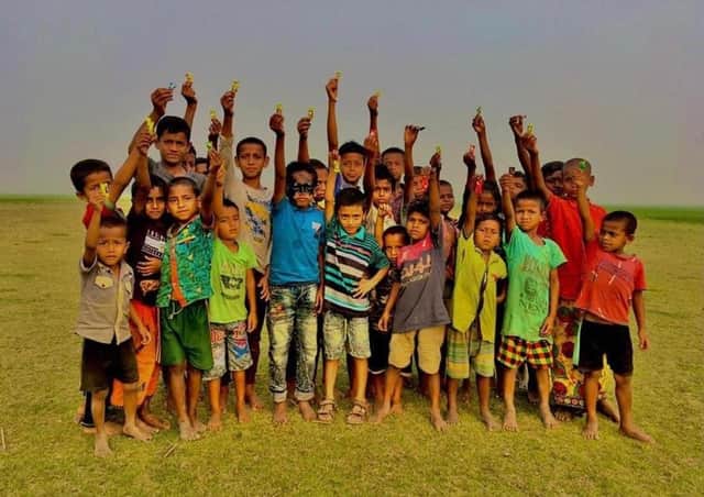 School children in Bangladesh show off their Covid-19 wristbands.
