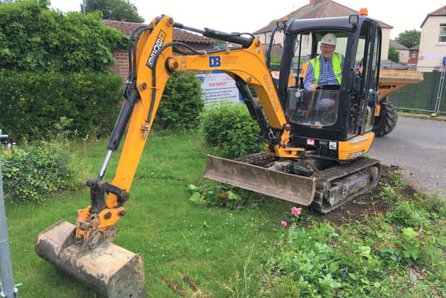 SKDC Cabinet Member for Housing and Property, Coun Robert Reid handles the digger at the new Bourne council housing development. EMN-210807-151014001