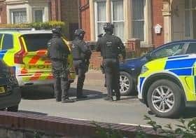An armed officer guards the door.