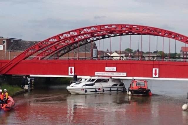 A boat gets stuck under a bridge. Photo: Broads Authority.
