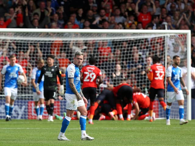 Sammie Szmodics of Peterborough United cuts a dejected figure as Luton Town celebrate scoring their second goal of the game, Photo: Joe Dent/theposh.com.
