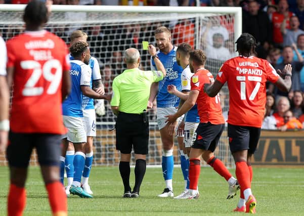 Mark Beevers of Peterborough United is shown a yellow card by match Referee Andy Woolmer at Luton. Photo: Joe Dent/theposh.com.