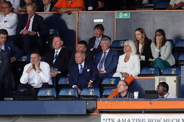 Sir Alex Ferguson watches on from the Kenilworth Road stands in the row behind Posh co-owner Darragh MacAnthony.