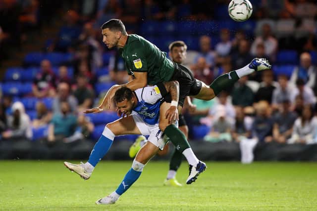Jorge Grant of Peterborough United is flattened by James Wilson of Plymouth Argyle. Photo: Joe Dent/theposh.com.