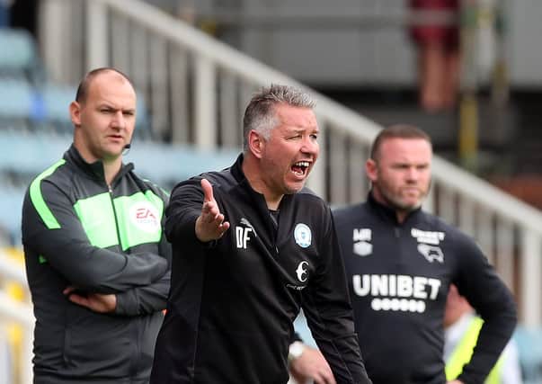 Peterborough United Manager Darren Ferguson issues instructions from the touchline alongside Derby County manager Wayne Rooney. Photo: Joe Dent/theposh.com.
