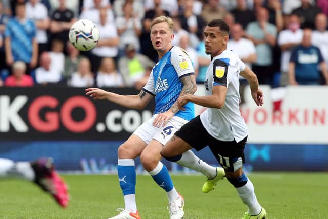 Frankie Kent of Peterborough United plays the ball beyond Ravel Morrison of Derby County. Photo: Joe Dent/theposh.com.