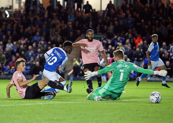 Siriki Dembele of Peterborough United gets the better of Perry Ng of Cardiff City to score the second goal of the game. Photo: Joe Dent/theposh.com.