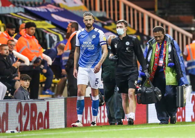 Posh centre-back Mark Beevers limps off injured during the game against Cardiff. Photo: Joe Dent/theposh.com.