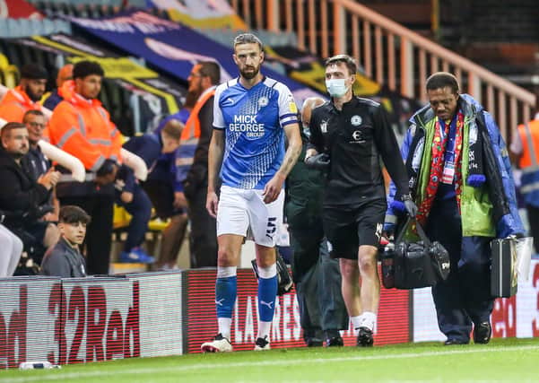 Posh skipper Mark Beevers limps out of the game against Cardiff. Photo: Joe Dent/theposh.com.