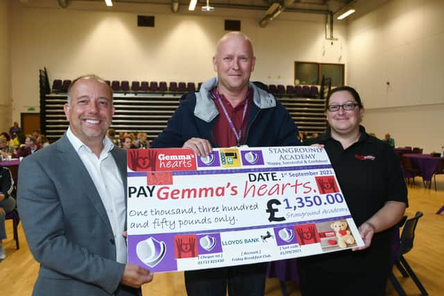 Stanground Academy Principal Gary Carlile with food technology teacher Mike Schofield present a cheque for £1,350 to Gemma Saunders from Gemma's Hearts for a defib machine. The money was raised from weekly staff breakfasts cooked by Mike EMN-210109-142733009