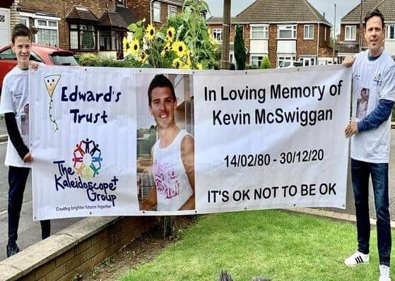 Matthew McSwiggan and his son with the banner which they will take to the top of Mount Snowdon.