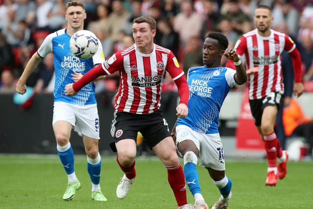 Siriki Dembele of Peterborough United in action with John Fleck of Sheffield United. Photo: Joe Dent/theposh.com
