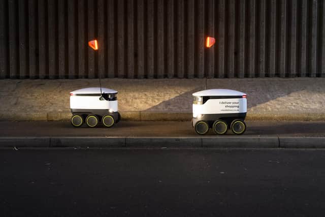 Two delivery robots pass on the pavement as they make home deliveries of groceries from a Co-op food store in Milton Keynes, England. Created by two of the co-founders of Skype in 2014,
 Starship has developed the self-driving pods to carry out a number of logistical tasks, with the ability to travel up to three miles, avoiding obstacles while negotiating roads and people as they move. The company claims that the robots have travelled over 100,000 miles in tests at sites across the world. (Photo by Leon Neal/Getty Images).