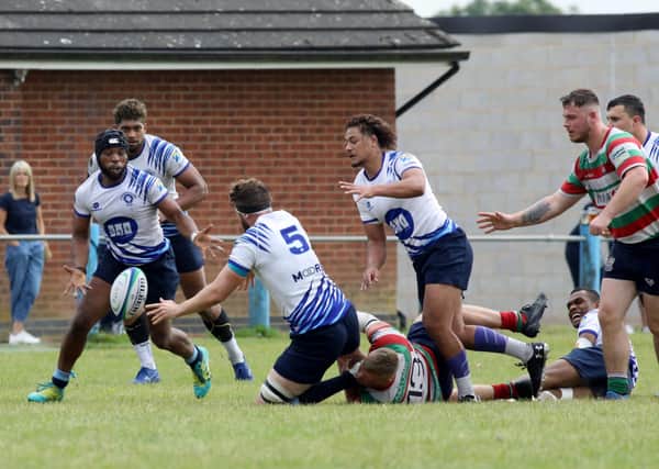 Josh Walker of Peterborough Lions offloads to Matthew Worral-Claire during the defeat Lutterworth. Photo: Mick Sutterby.