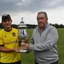 Peterborough Town skipper David Clarke receives the Northants Premier Division trophy from Northants League chairman David Hartley. Photo: David Lowndes.