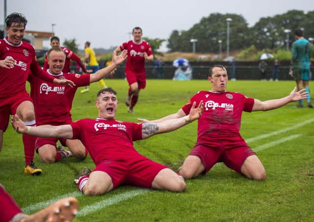 Cameron Johnson (centre) leads the celebrations after his last-gasp penalty delivered an FA Cup win for Stamford AFC against Norwich United. Photo: James Richardson.