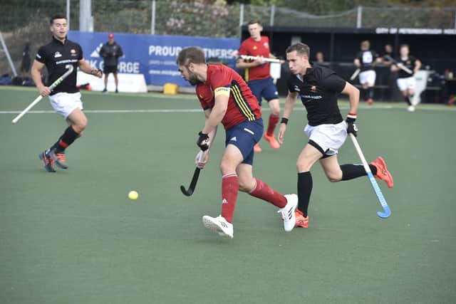 City of Peterborough HC skipper Joe Finding (red) on the ball against Cardiff. Photo: David Lowndes.