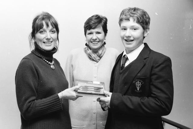 Kieran Coyle, 11N, St. Joseph’s, whose poem ‘Christmas’ was published in a new anthology ‘Poetry Now NI 1997, being presented with a gift from principal, Mrs. Sarah Kelly. Also in the picture is school librarian, Mrs. McCrystal.