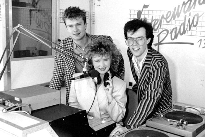 Hereward Radio presenters shortly after the station launched in 1980 when the studios were based at the bottom of Bridge Street near Town Bridge. “The station you can really call your own” continued as Peterborough’s premier local radio station until 2009 when it was rebranded and swallowed up by Global Radio’s Heart FM network. Pictured here are (L-R): Shaun Tilley (now with Sunshine Radio), Paula Ann Bland (later to star in Grange Hill) and Dave King (still working locally with Steve Allen Entertainments).