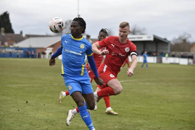 Peterborough Sports goalscorer Maniche Sani (blue) in action against Brackley. Photo: David Lowndes