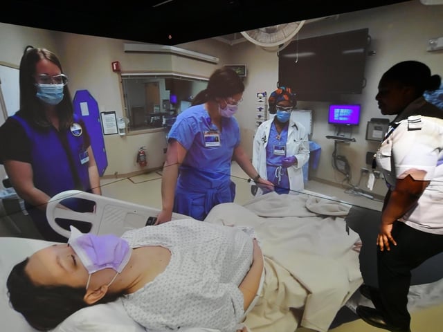 A trainee nurse watches a simulated hospital ward at the XRP eXtended Reality Peterborough centre at ARU Peterborough