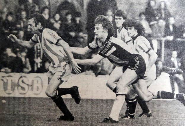 Posh legend Tommy Robson (left) playing against Cambridge United in 1977.