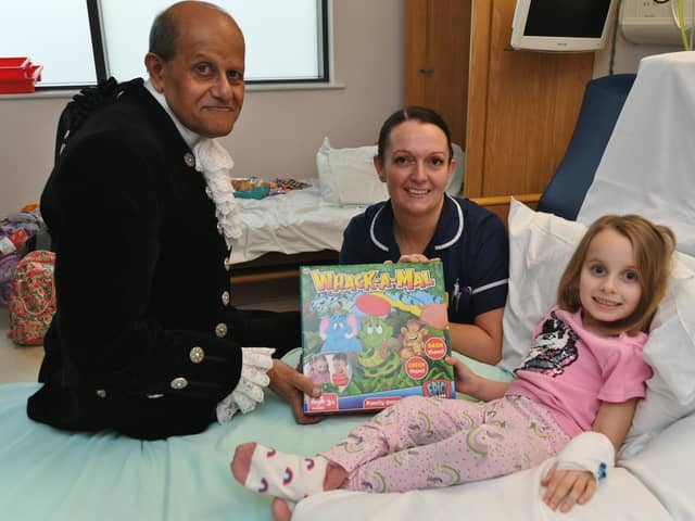 High Sheriff of Cambridgeshire Dr Barat Khetani presenting Christmas gifts for children in the Amazon Ward at City Hospital with Sister Erika Davies and young patient Sophie Stapleton (6).