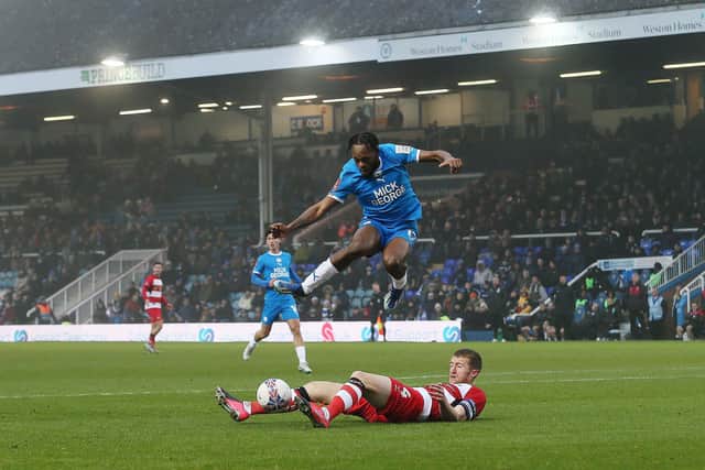 Ricky-Jade Jones of Peterborough United skips over a challenge from Tom Anderson of Doncaster Rovers. Photo: Joe Dent/theposh.com.
