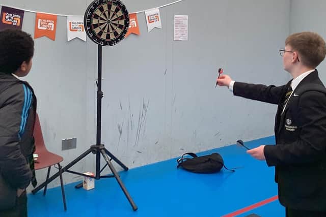 Students playing darts at the fundraiser