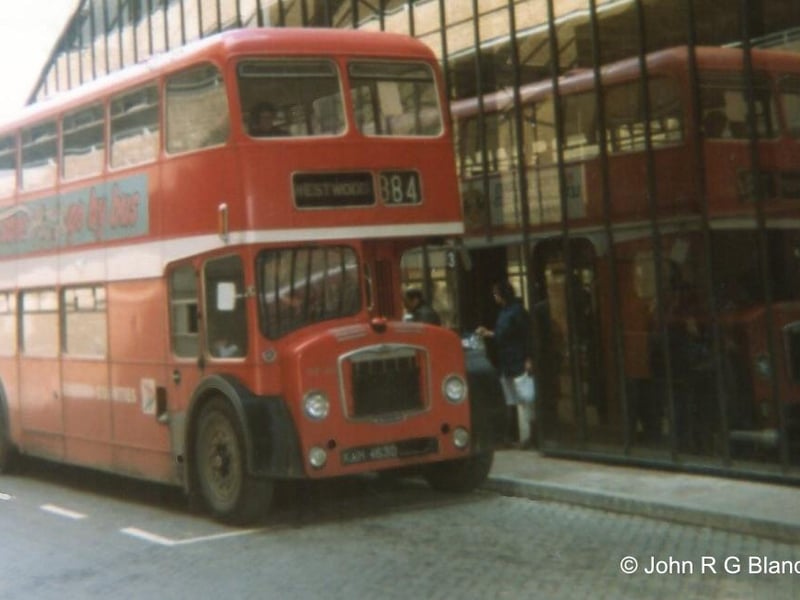 A classic red double decker bus stops at the new station