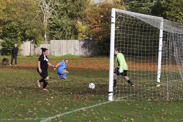 Katie Steward (blue) completes her hat-trick for Peterborough Sports at Waterbeach. Photo: Tim Symonds.