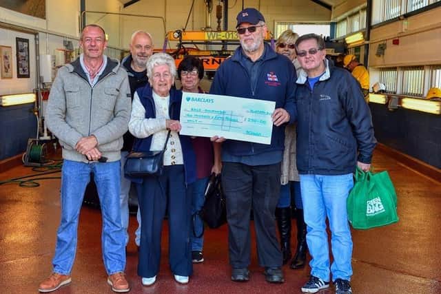 Jo Smith presents a cheque to Paul Stewart, deputy launch authority at Hunstanton RNLI with family members in the station's hovercraft hangar.