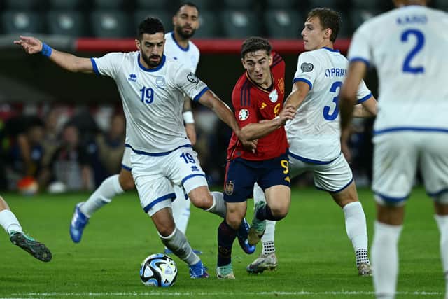 Hector Kyprianou battles with Spain's Gavi. (Photo by Jewel SAMAD / AFP) (Photo by JEWEL SAMAD/AFP via Getty Images)