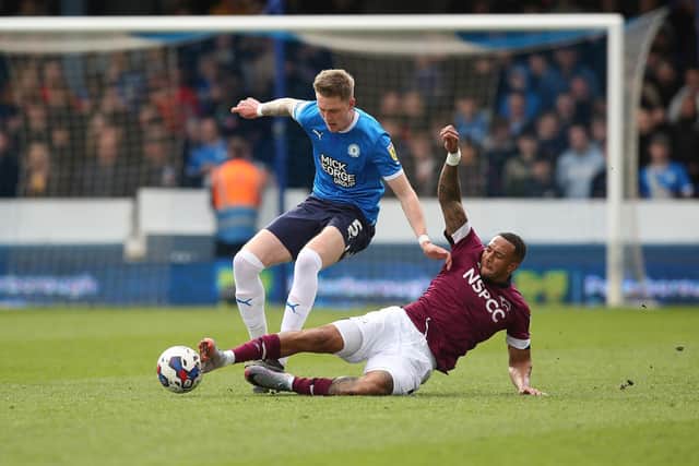 Josh Knight of Peterborough United in action with Nathaniel Mendez-Laing of Derby County. Photo: Joe Dent/theposh.com.