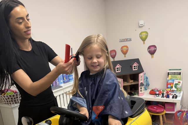Tom Butler (3) of Peterborough has his hair cut by Erica for the Little Princess Trust