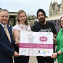 Mark Hernandez and Del Singh presenting a cheque to Sarah Piggott and Tracy Spring of Nene Valley Railway from money raised through the Octopussy Bond weekend
