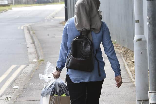 An Ideal World TV employee leaves the firm's premises in Newark Road, Peterborough, with her possessions in a plastic bag after being told of the company's collapse