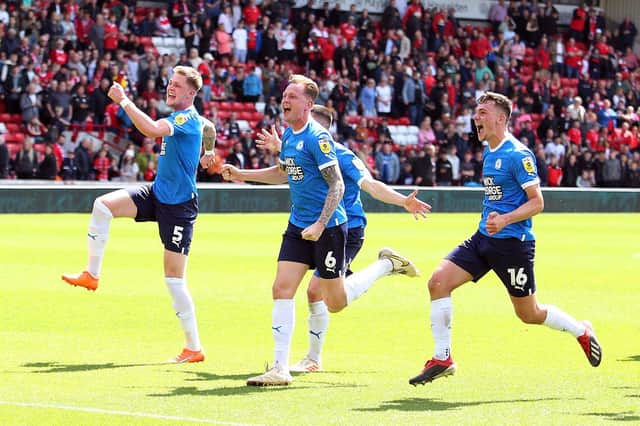 Peterborough United players celebrate securing a play-off place at full-time against Barnsley. Photo: Joe Dent.