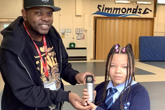 Xidus Pain and the “Microphone of Peace” at Discovery Primary Academy.