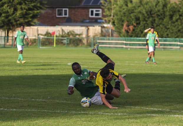Romeo Ugbene (green) of FC Peterborough was sent off for this foul against Crowland. Photo: Tim Symonds.