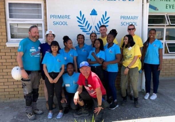 Sean Dennis (far left), seen here with a former build team, will be leading a team of seven volunteers from our region to help build new schools in the Western Cape township of Lwandle in November.
