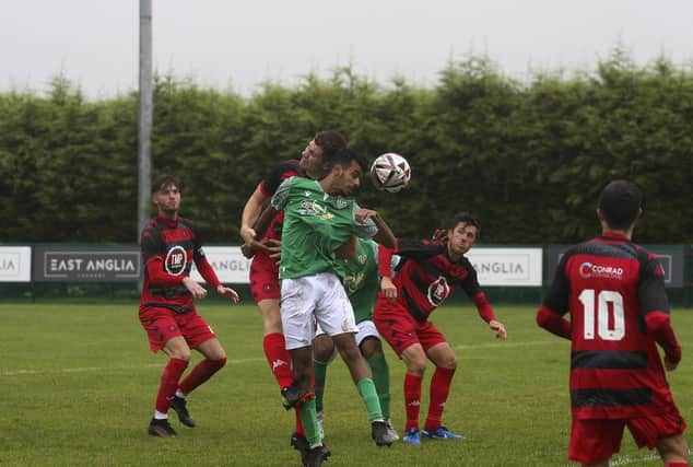 Ayman Trabelsi *green) heads goalwards for FC Peterborough against Framlingham. Photo: Tim Symonds