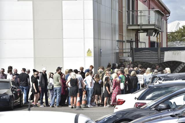 Shocked staff gather outside Ideal World TV in Peterborough after being told their jobs had been lost with the collapse of the business