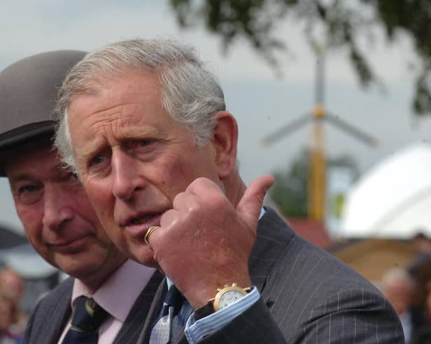 Prince Charles steps carefully through the mud during a visit to the East of England Showground in 2012
