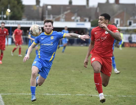 New Peterborough Sports signing Jordan Crawford (blue) in action during his goalscoring debut against Brackley. Photo: David Lowndes