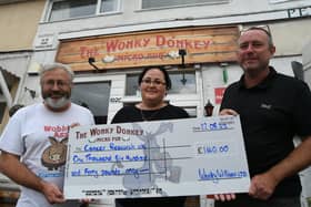 Dave and Andrew Williams from the Wonky Donkey microbar, in Fletton High Street, present a cheque to Marina Staudze, manager of the Cancer Research UK shop, in Westgate