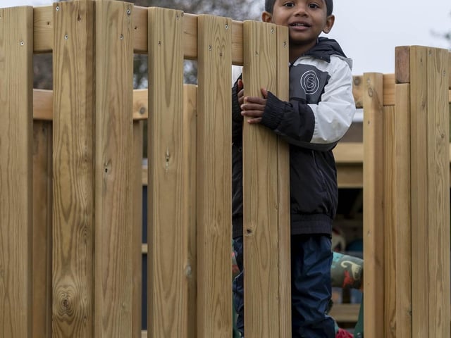 A pupil has fun on one of the wooden play towers