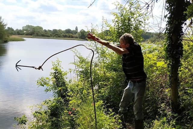 Harry Machin using a grappling hook to remove litter